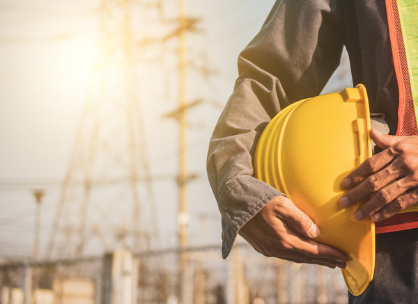 Power-line worker holding a hard hat