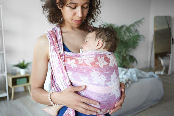 Mother carrying baby in a baby sling
