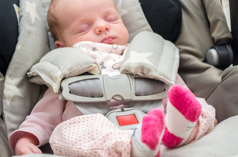 Sleeping newborn in a capsule-style car seat