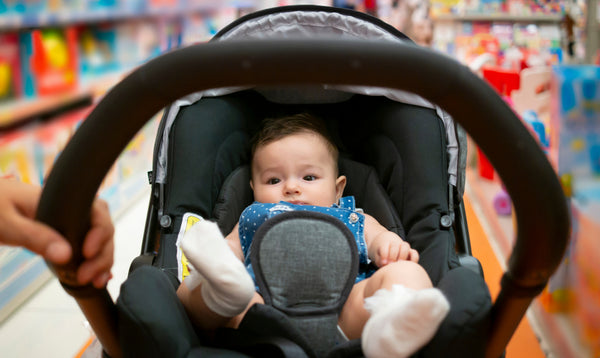 Baby taken out shopping in a baby capsule