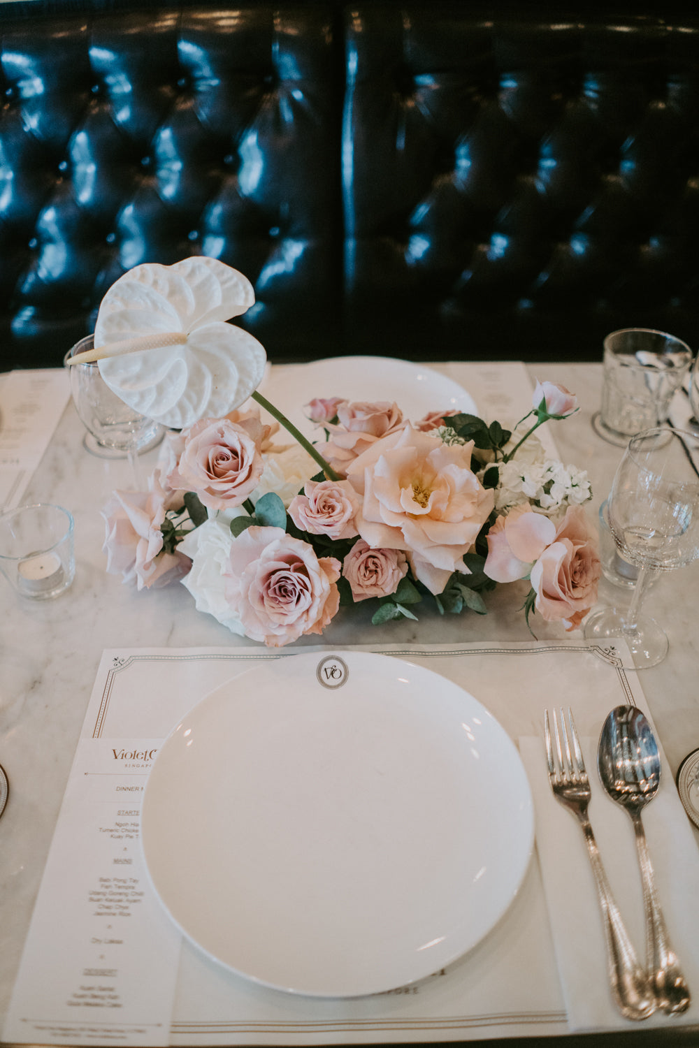 Clean floral centrepiece of anthurium and roses at fine dining Peranakan Violet Oon restaurant Singapore