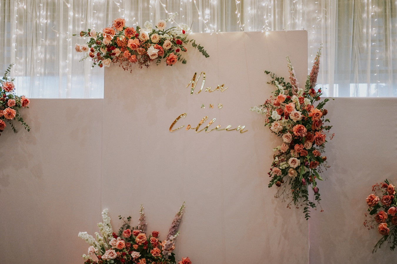 Freestanding hanging floral installation on white backdrop with fairy lights for wedding stage at Park Royal Hotel Singapore