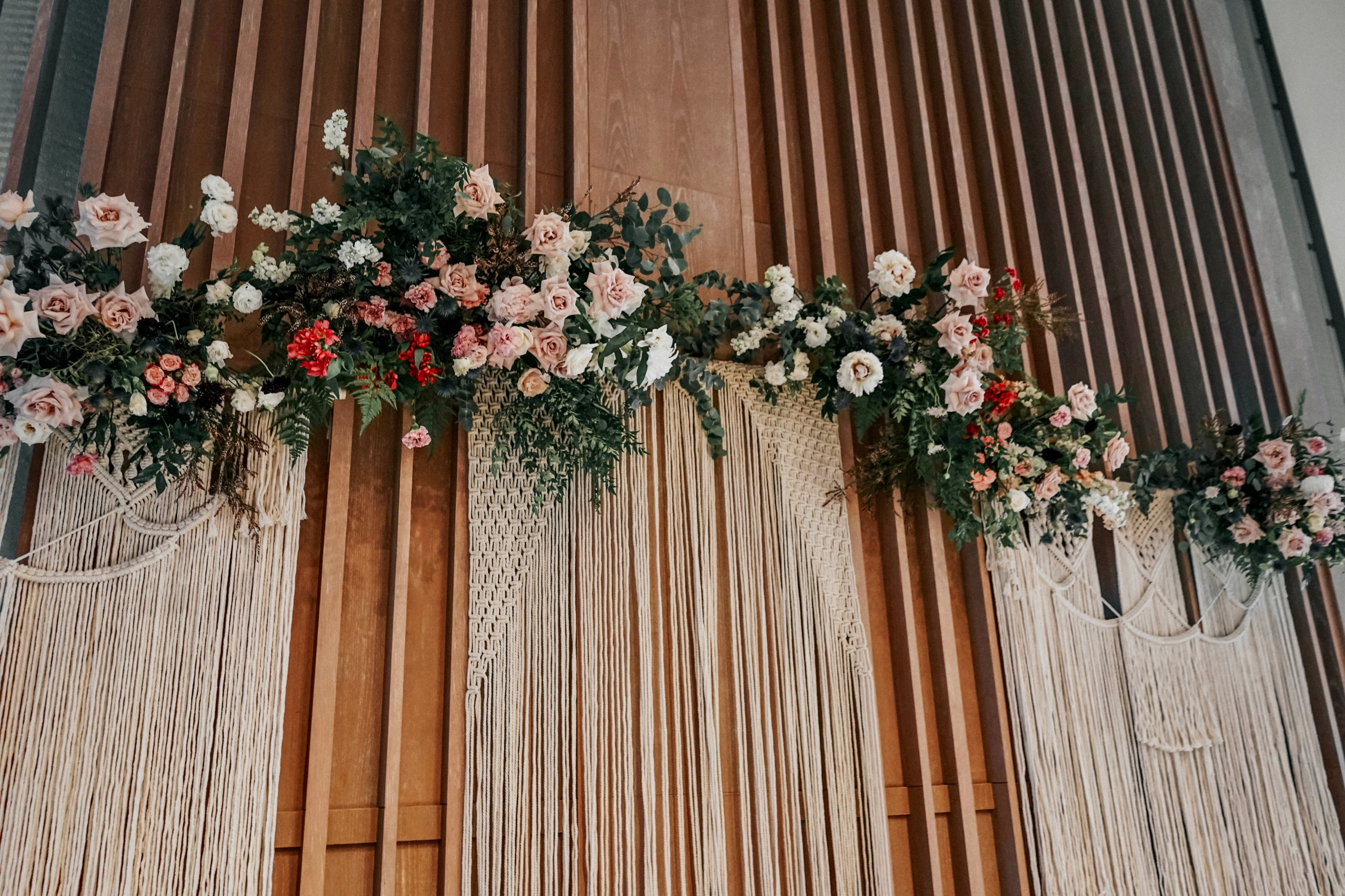 Macrame backdrop and flowers arranged above VIP table for an Andaz Hotel wedding reception