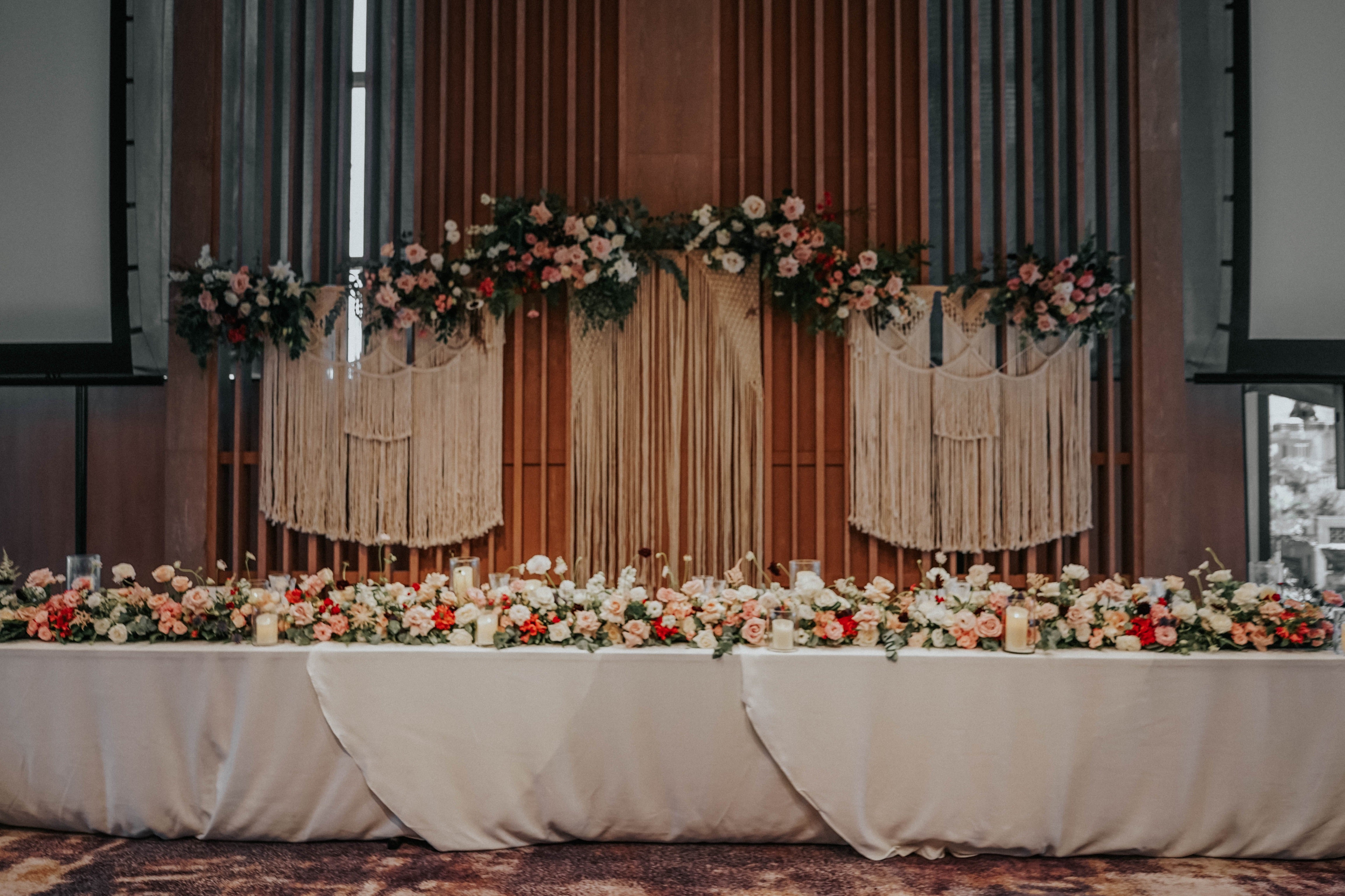 Long white wedding dinner table decorated with lush flowers lining the table design at Andaz Hyatt Singapore Hotel