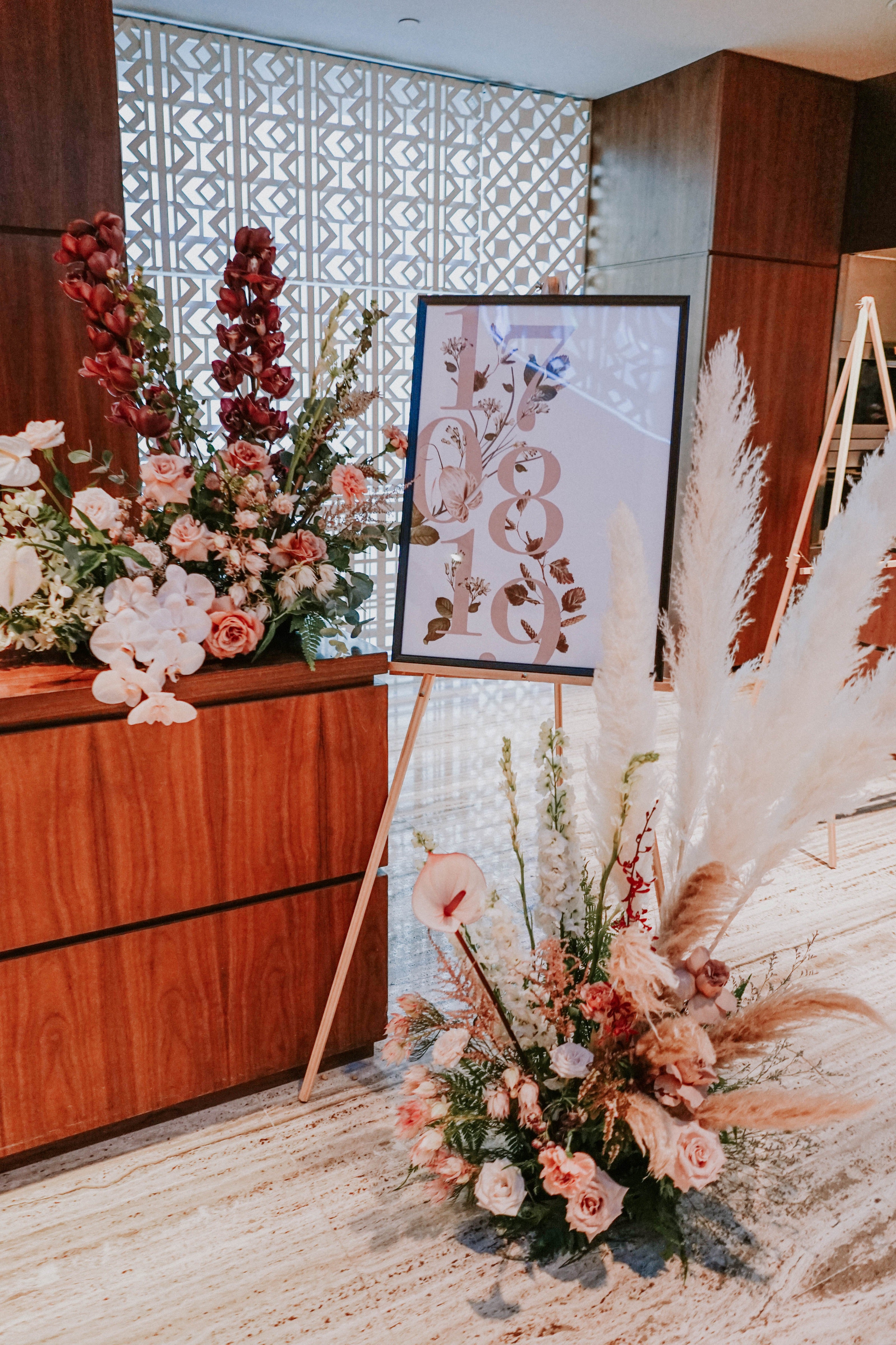 Romantic minimalistic welcome signage for wedding ceremony decorated with orchids and pampas floral installations at Grand Hyatt Singapore