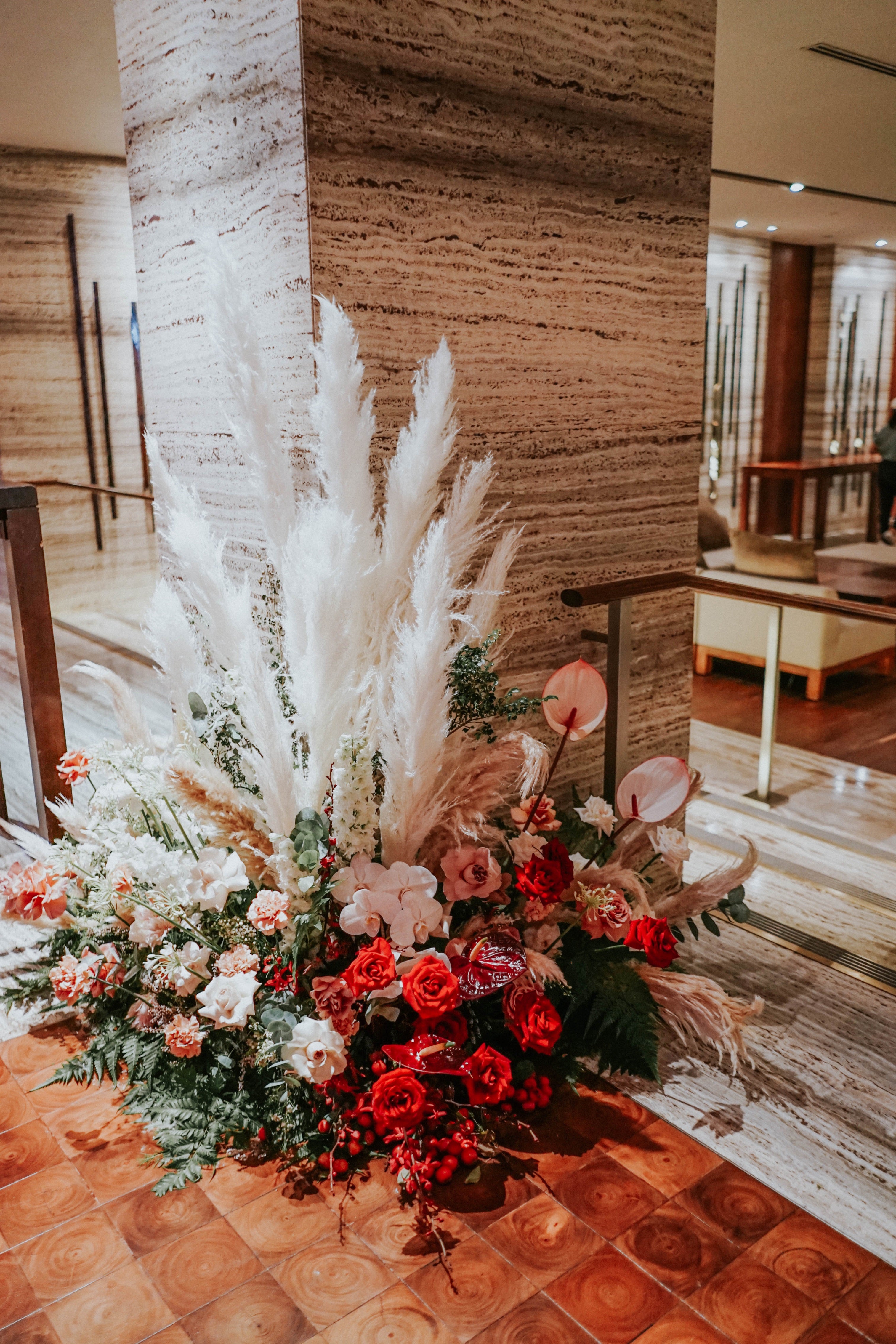 Corner standing pampas, red roses, cherry lined anthurium and lush greens floral installation at Grand Ballroom Grand Hyatt Singapore Hotel