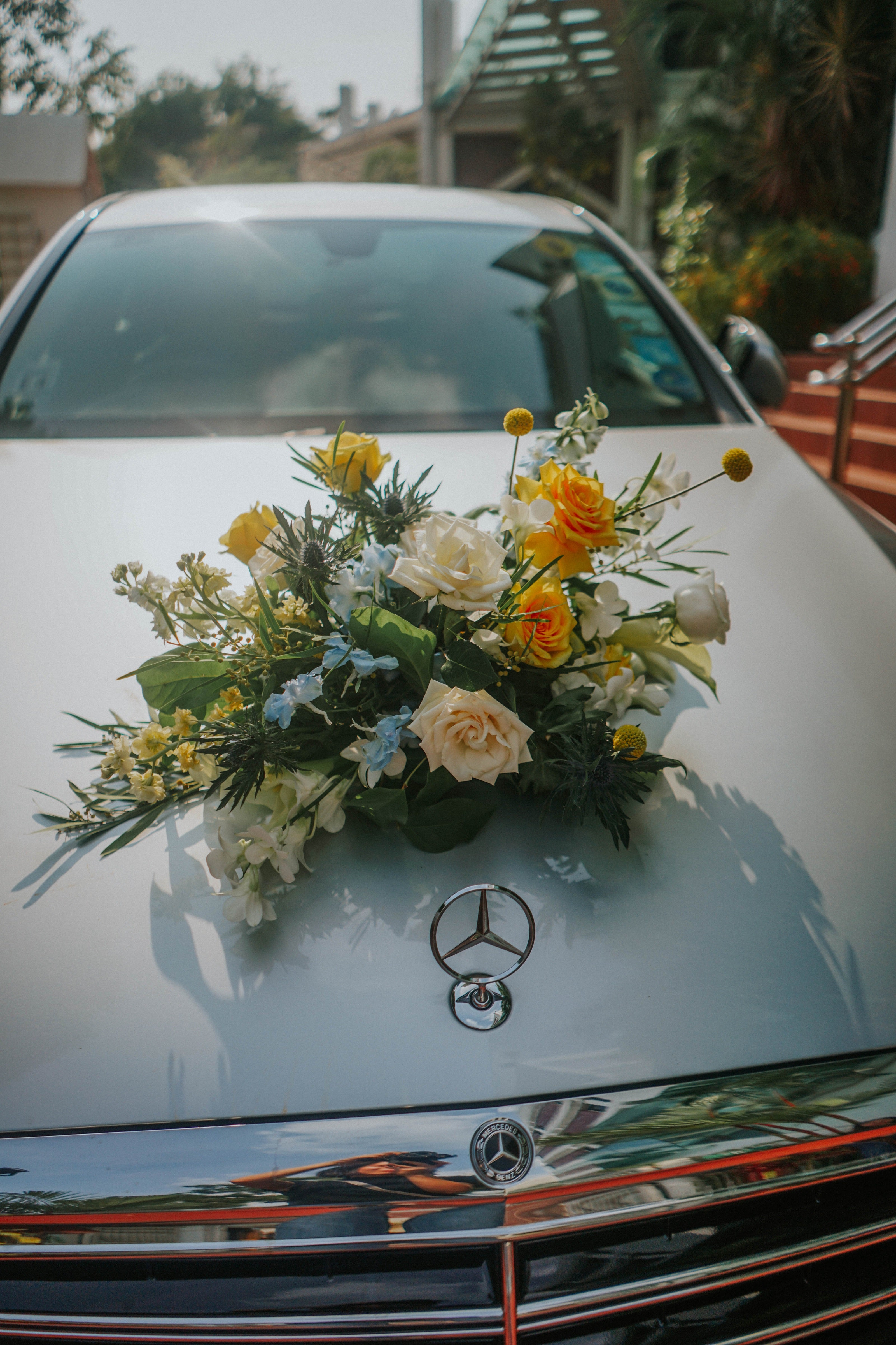 Wedding car decoration flowers on Mercedes under morning Singapore sunlight outside Wesley Methodist Church