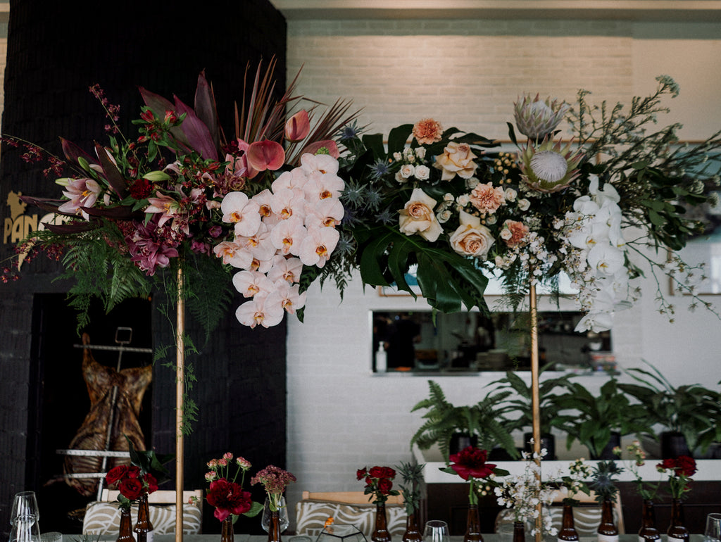 Tropical Elegance Red & Blush Floral Installation for an outdoor wedding at Panamericana Sentosa Singapore. Tall floral table centerpiece installation