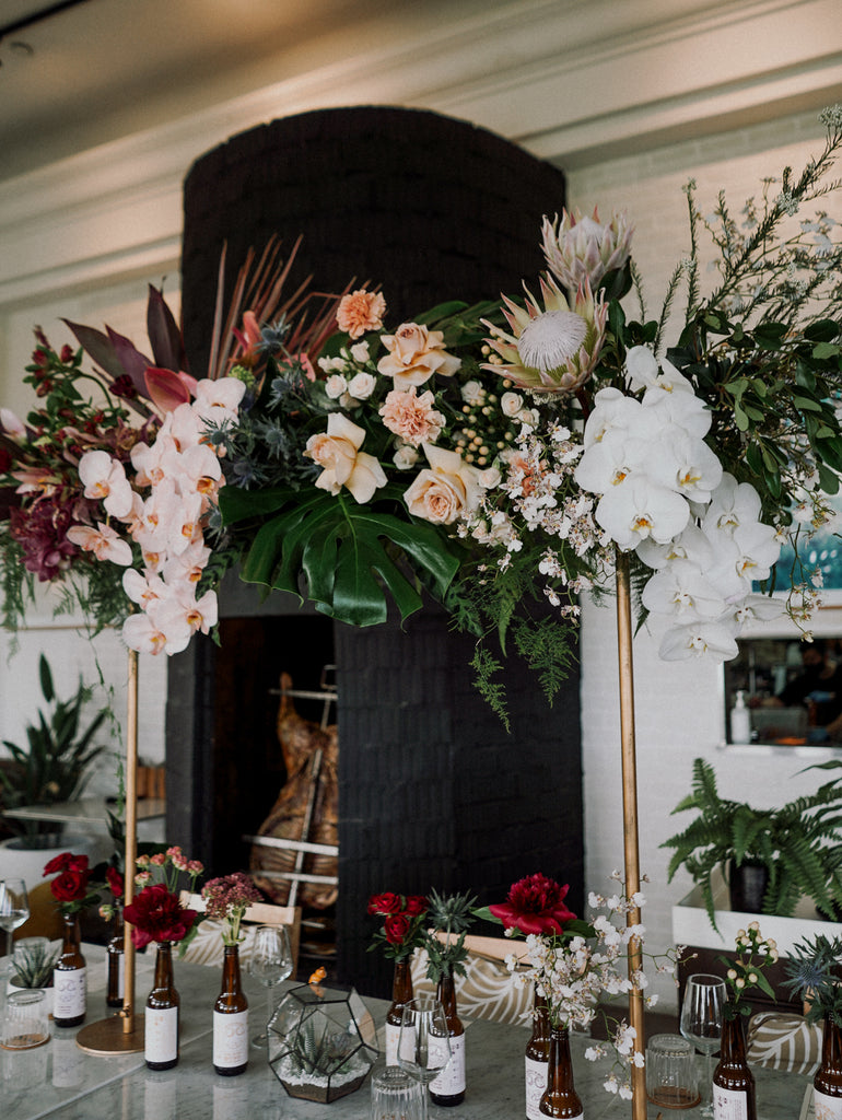 Tropical Elegance Red & Blush Floral Installation for an outdoor wedding at Panamericana Sentosa Singapore. Beer bottle flowers