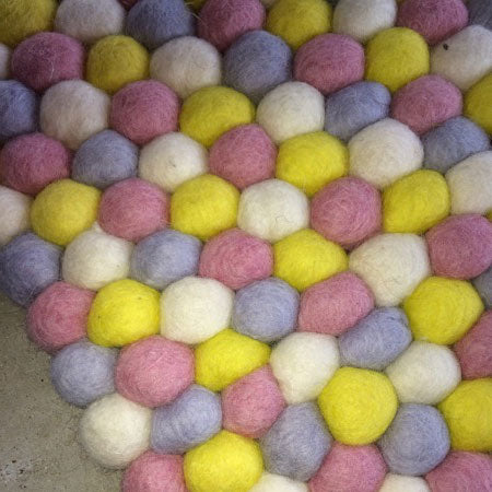 yellow and pink felt ball rug