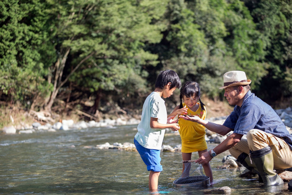 Father showing a catched fish to their children