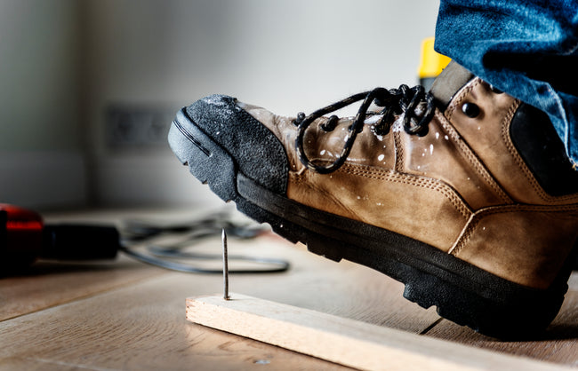 man in boots with puncture resistant soles steps on a nail