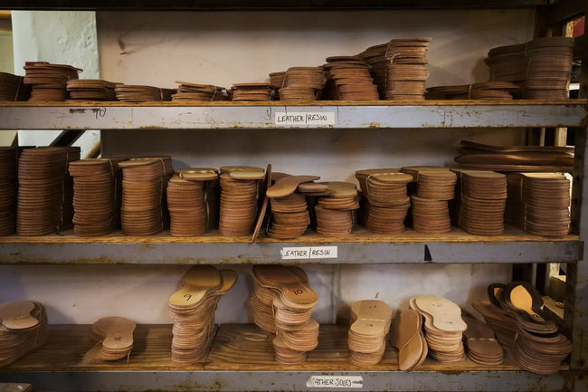 close up of stacks of leather soles on shelves in workshop