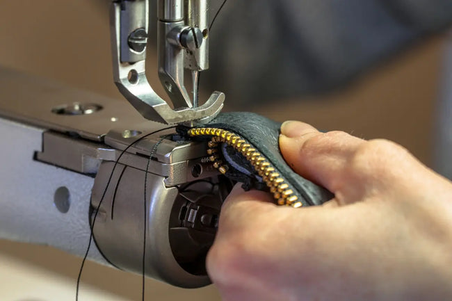 close up of hand and the machine making side zip work boots