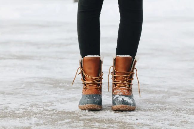 woman standing in her rubber sole boots on the snow