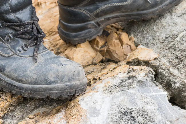 black durable trekking leather boots on the rock