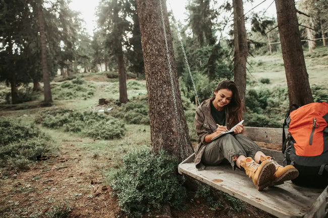 woman sitting in the forest in her timberland boots