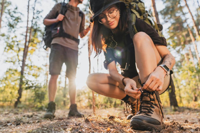 woman tying hiking boot outdoors