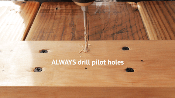 Drilling pilot holes in modern reclaimed wood dining table