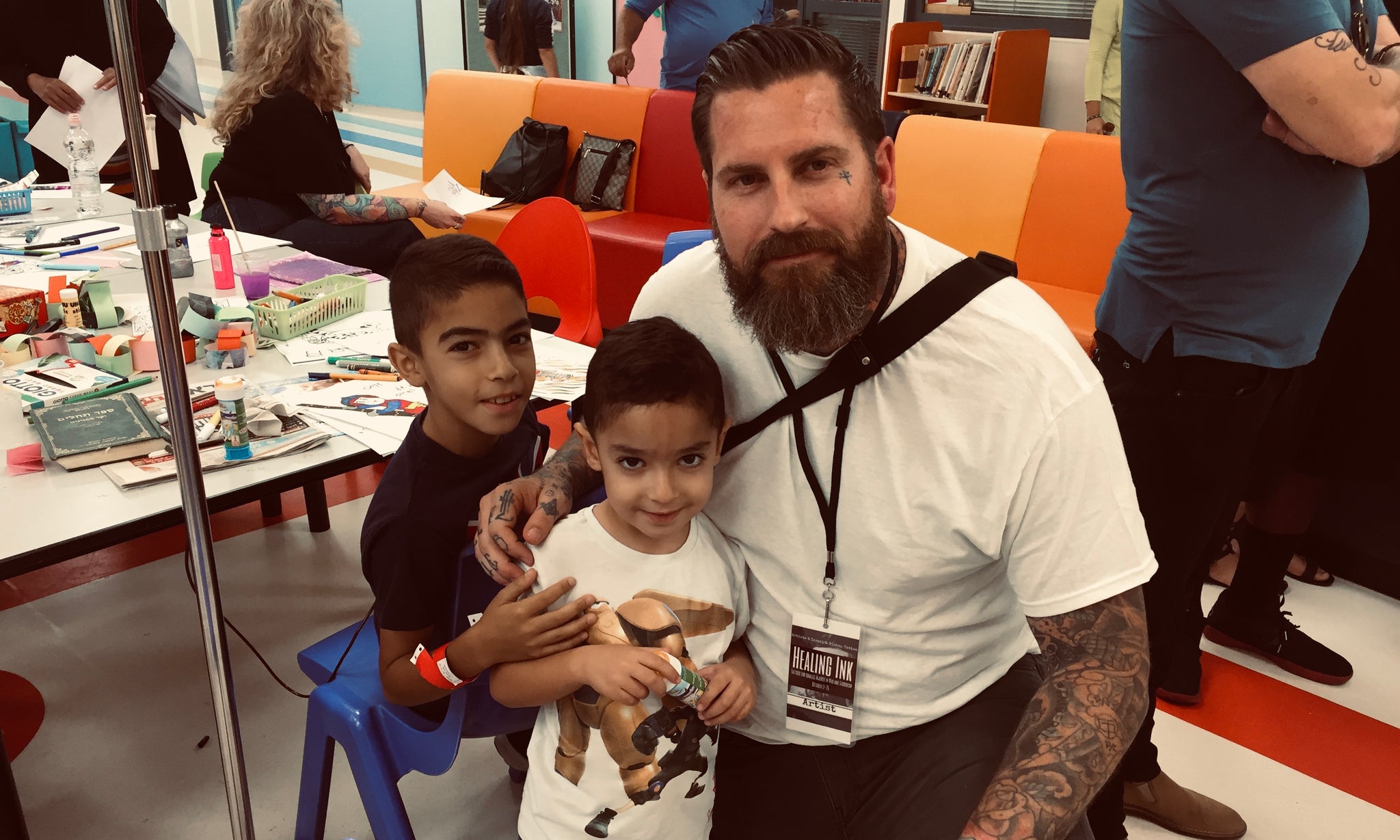 Tattoo artist Luke Wessman with kids in a hospital doing art to lift their spirits