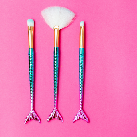 Mermaid makeup brushes on pink background