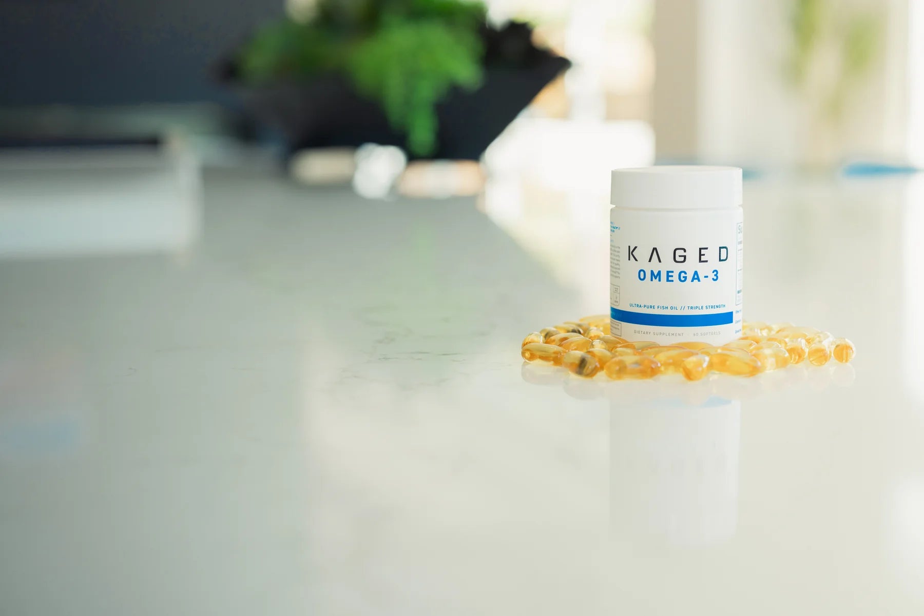 Kaged omega-3 bottle with capsules on reflective white surface, clean background.