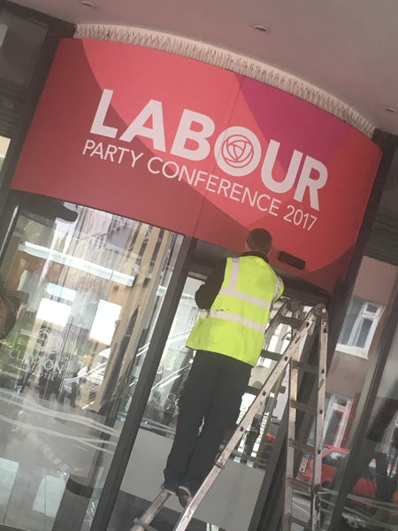 A large temporary graphic installed by Barrow Signs on a circular panel above the revolving door at the hotel entrance