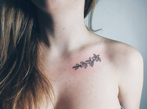 Tiny leaf tattoo on girl's collarbone. 