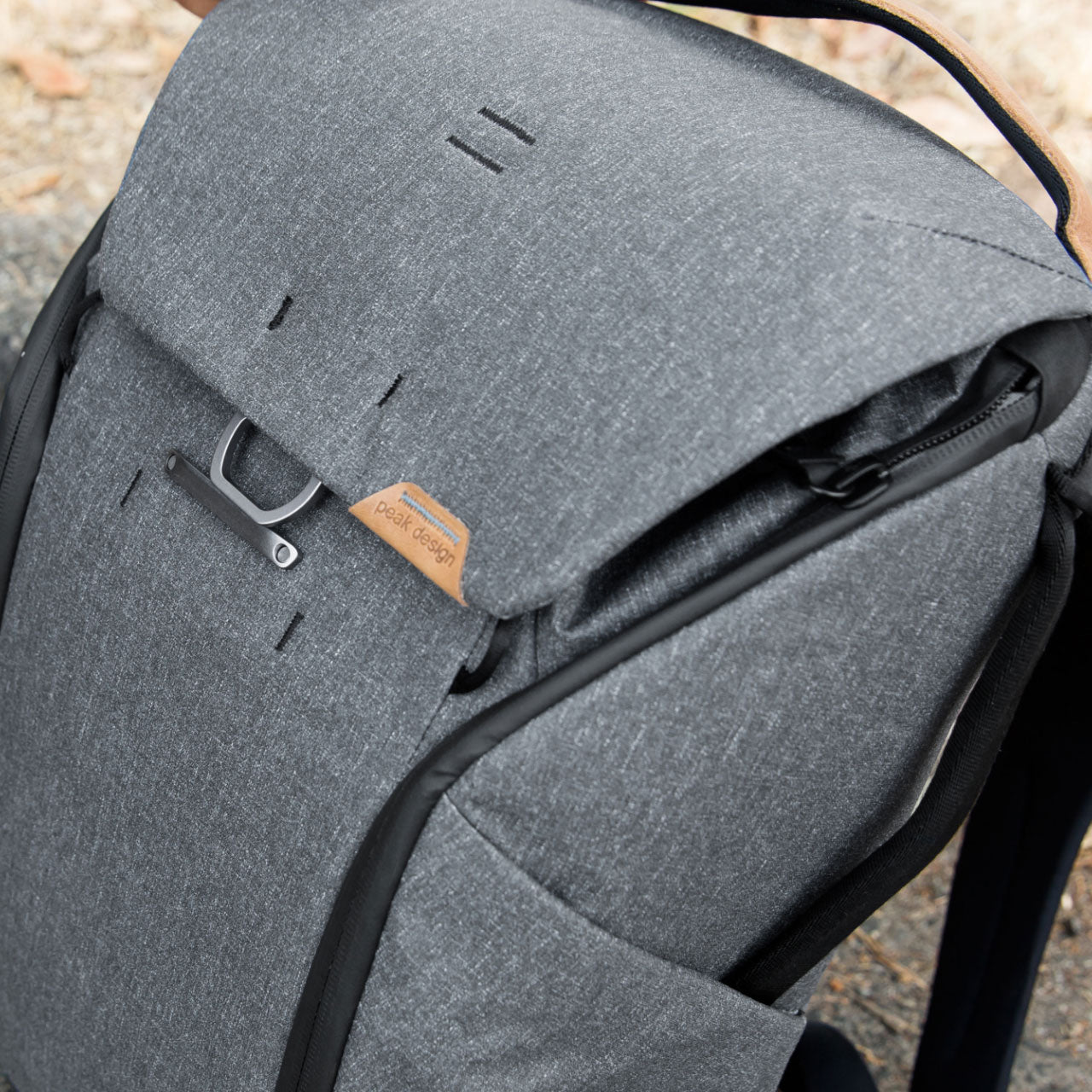 Man opening side zipper of Everyday Backpack