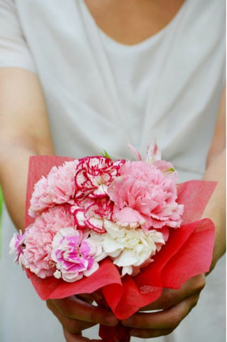Celebrating Motherhood - Giving Mother a bouquet of Carnation