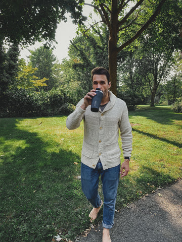 man drinking out of tumbler. 