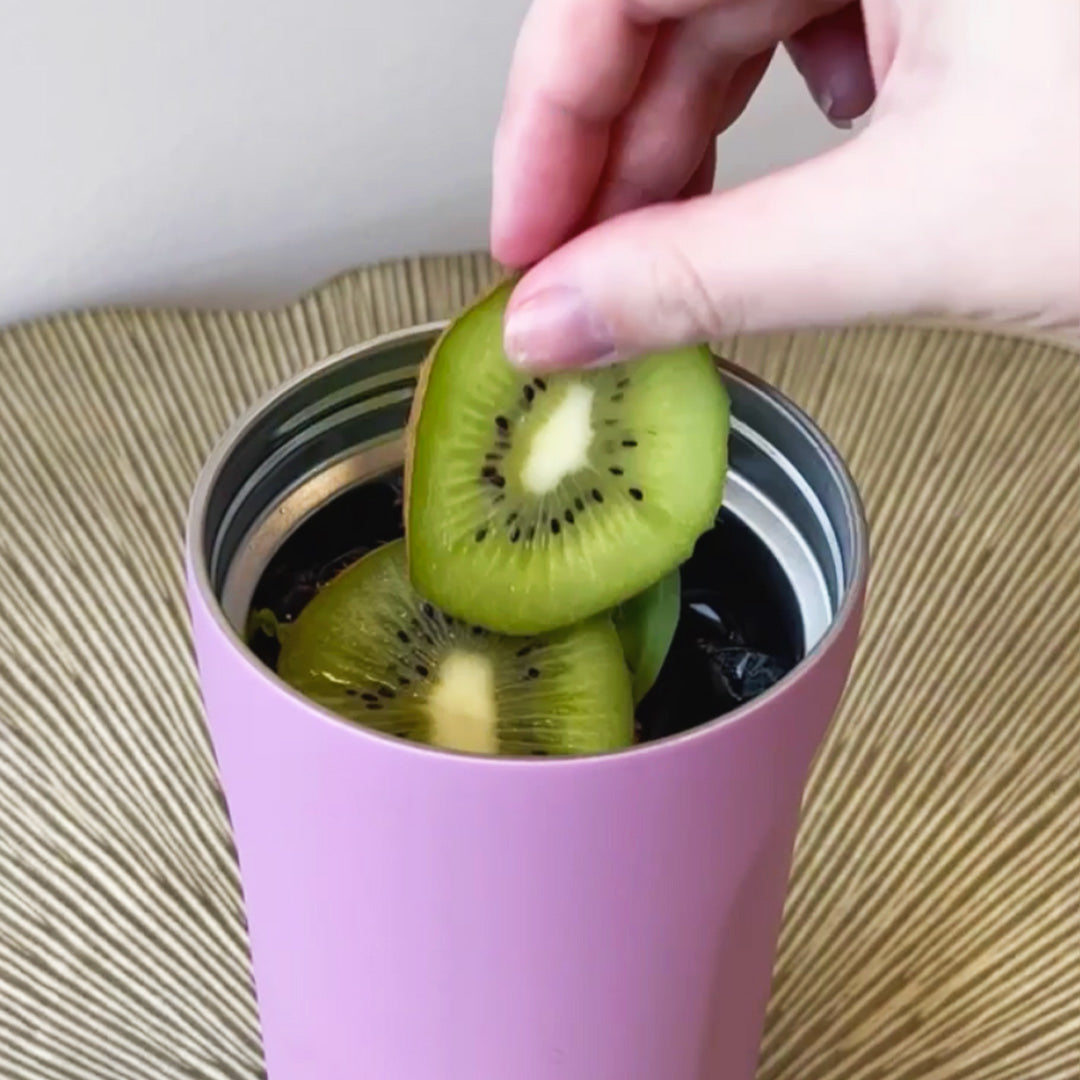 person putting kiwi in multishaker.