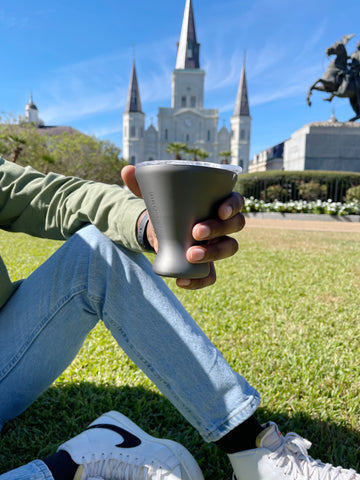 person holding tumbler by disney castle.