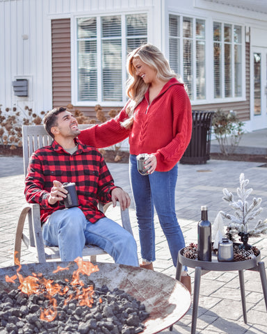couple sitting by outdoor fireplace.