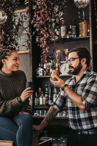 people sitting at bar with drinks.