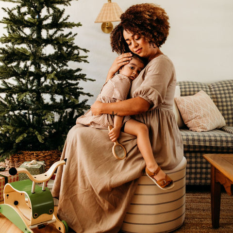Mother holding child by christmas tree