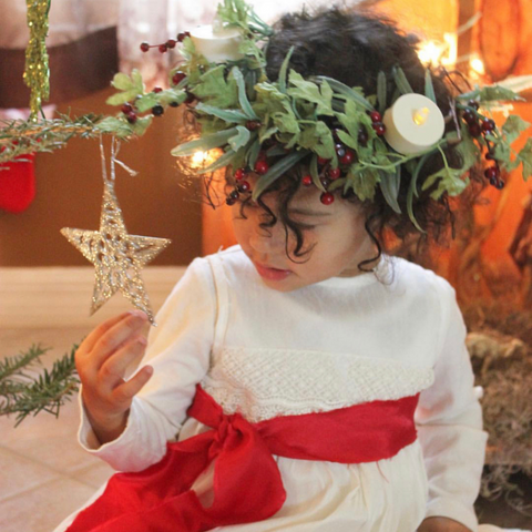 A young girl dressed as Lucia for St. Lucia Day - Bella Luna Toys