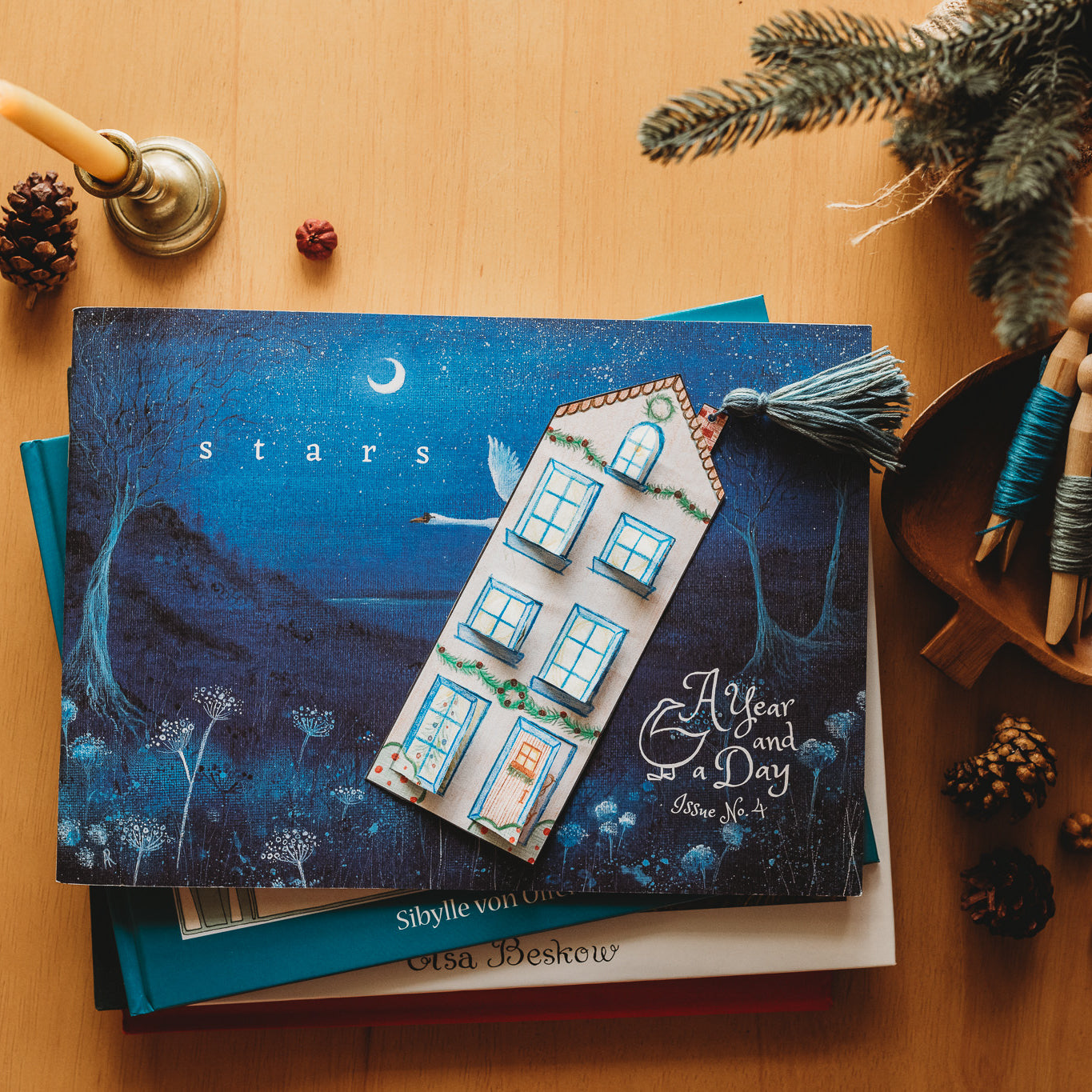 A cozy bookmark sits on a blue book.