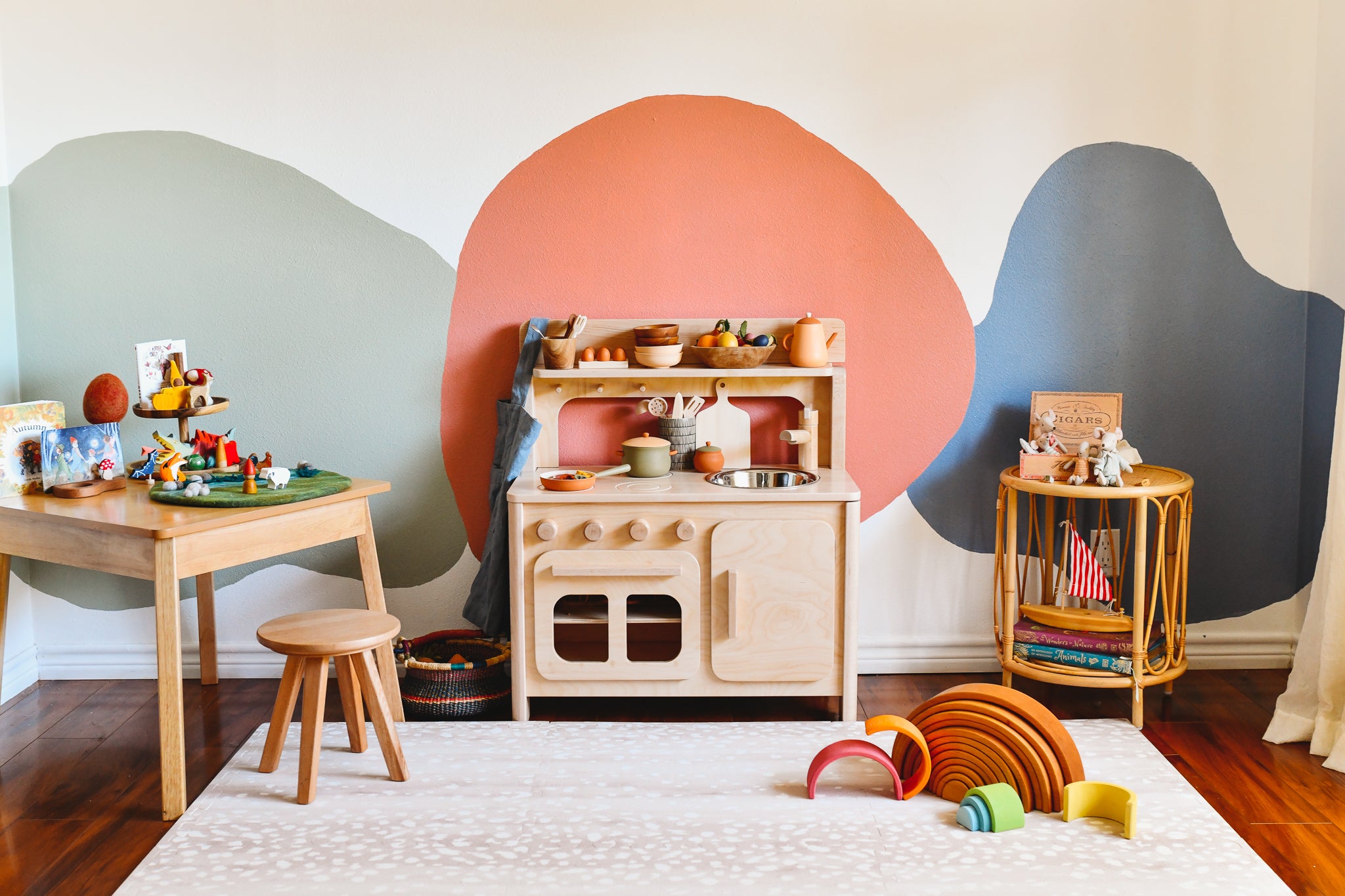 There is a play kitchen in a colorful child's playroom.