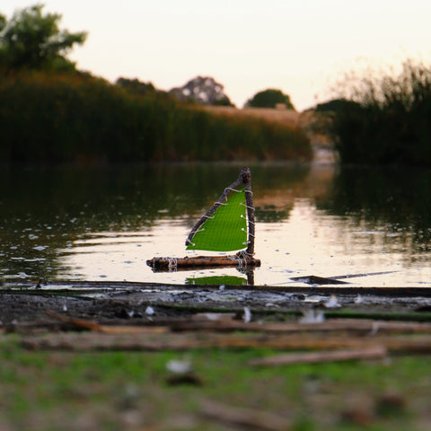 DIY toy raft made from sticks and leaves floating on the water