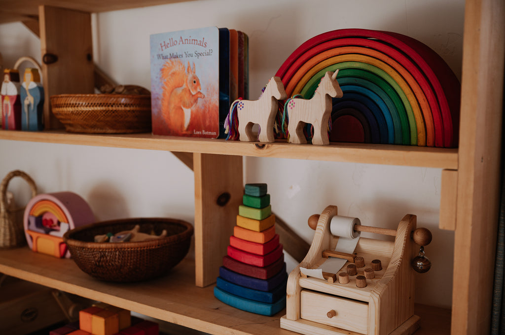 An assortment of wooden toys on a curated toy shelf