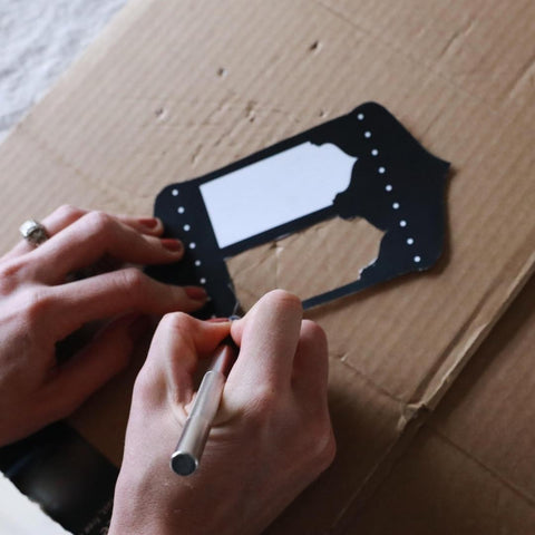 Person using craft knife to cut detailed shapes out of the Ramadan Window Lantern templates