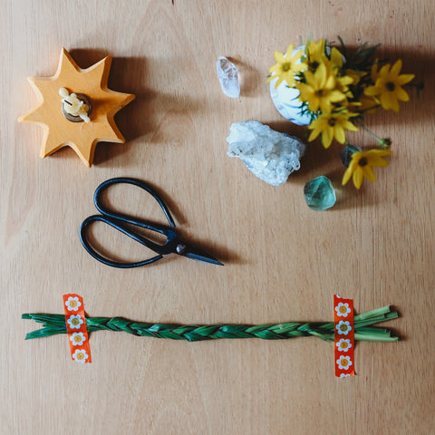 A length of grass braided together and stuck to a table with washi tape. 