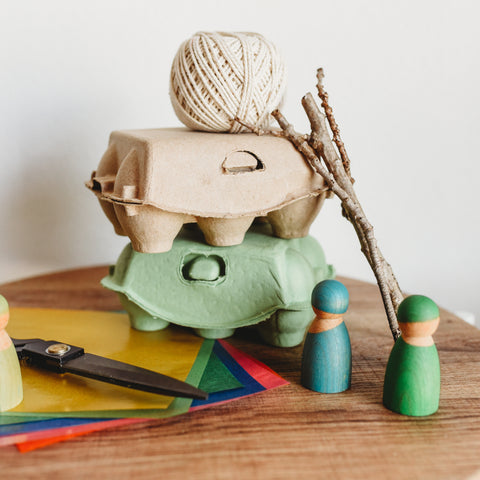 Egg cartons, sticks, string and kite paper to craft recylable toy boat.