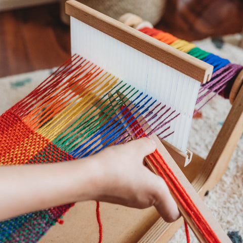 A child weaves with the Easy Weaver Loom from Bella Luna Toys
