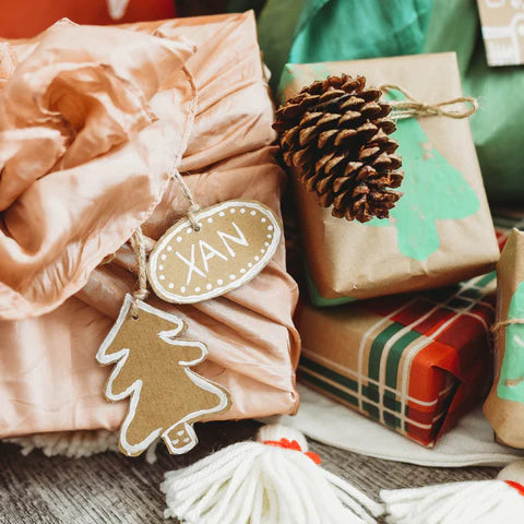 A group of presents with a handmade label sit under a tree.