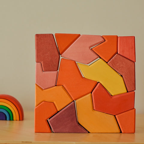 Blocks representing choleric temperament from Grimm's Wooden Toys four temperaments blocks set. Red, orange, and yellow blocks with sharp corners and lines