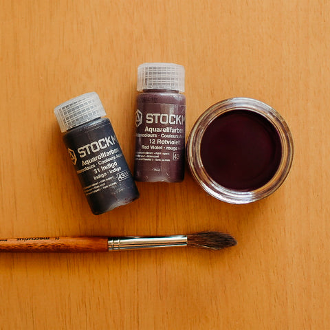 Stockmar watercolor paint in concentrated 10mL bottles next to a jar of the paint mixed