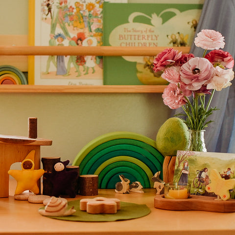 Table with spring flowers and waldorf toys representing a fairy world