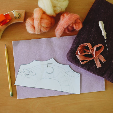 Template of a birthday crown laying on top of a piece of light purple wool felt